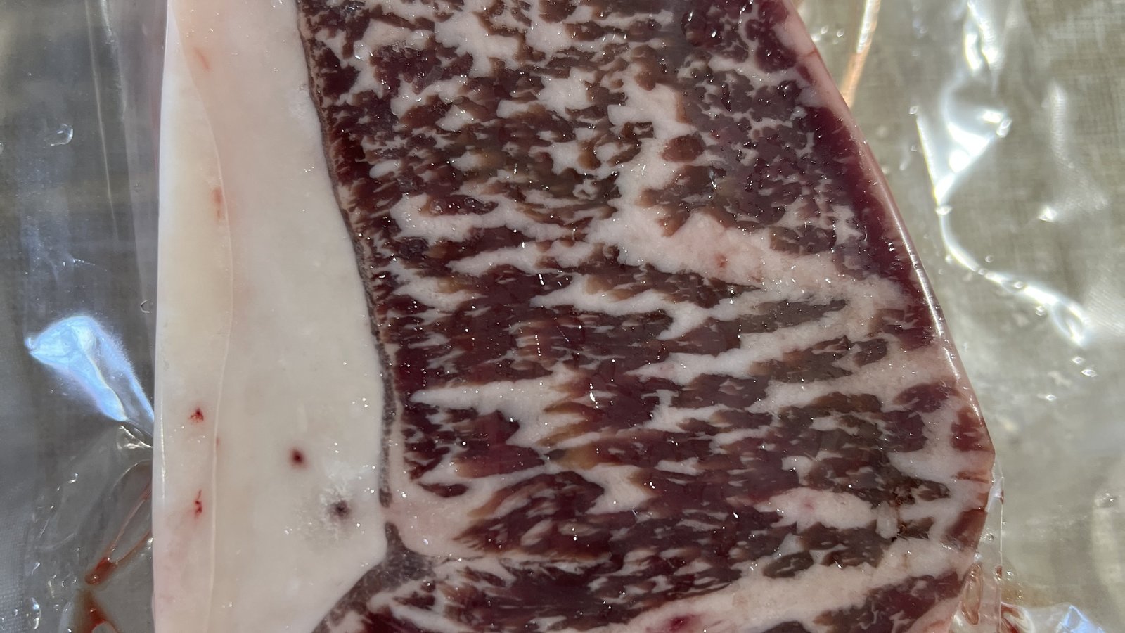 Wagyu KC strip, vacuum-sealed, dark dense marbling