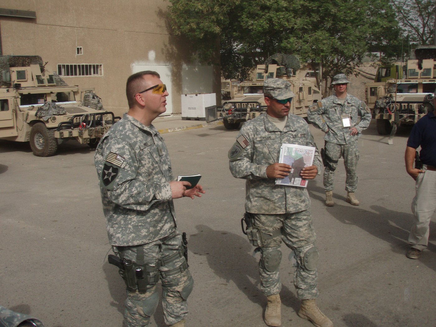 Then-Major Spivey delivering a mission brief beside staged Humvees, Iraq